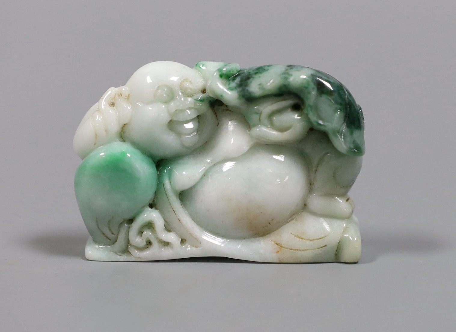 A Chinese jadeite Budai reclining figure, 6 cms wide